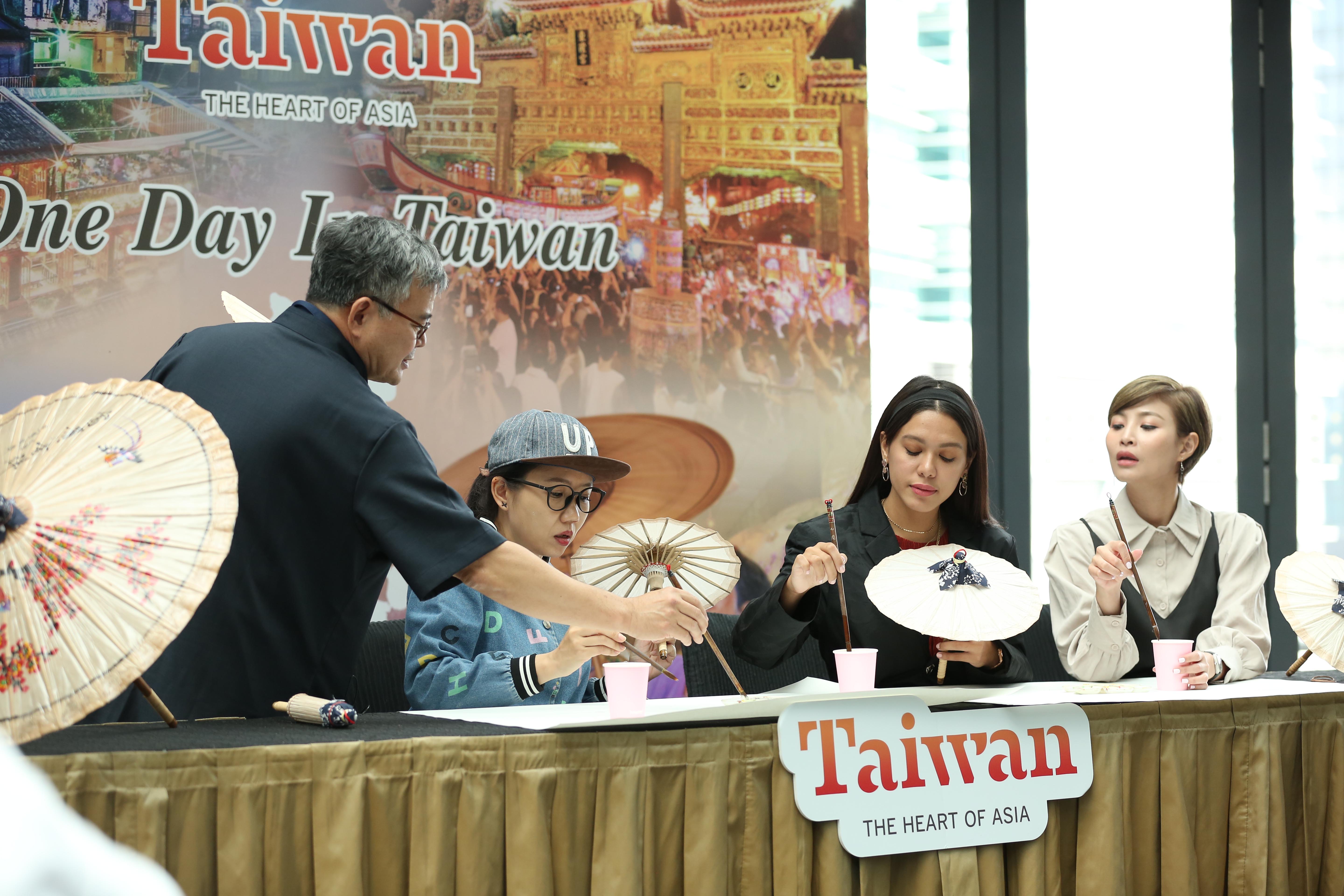 Oil-paper umbrella master from Taiwan  teaches YouTuber Cjlee (left 2), influencer Julia Farhana Marin and artist Janelle Chin(right) how to pain on this traditional umbrella. 