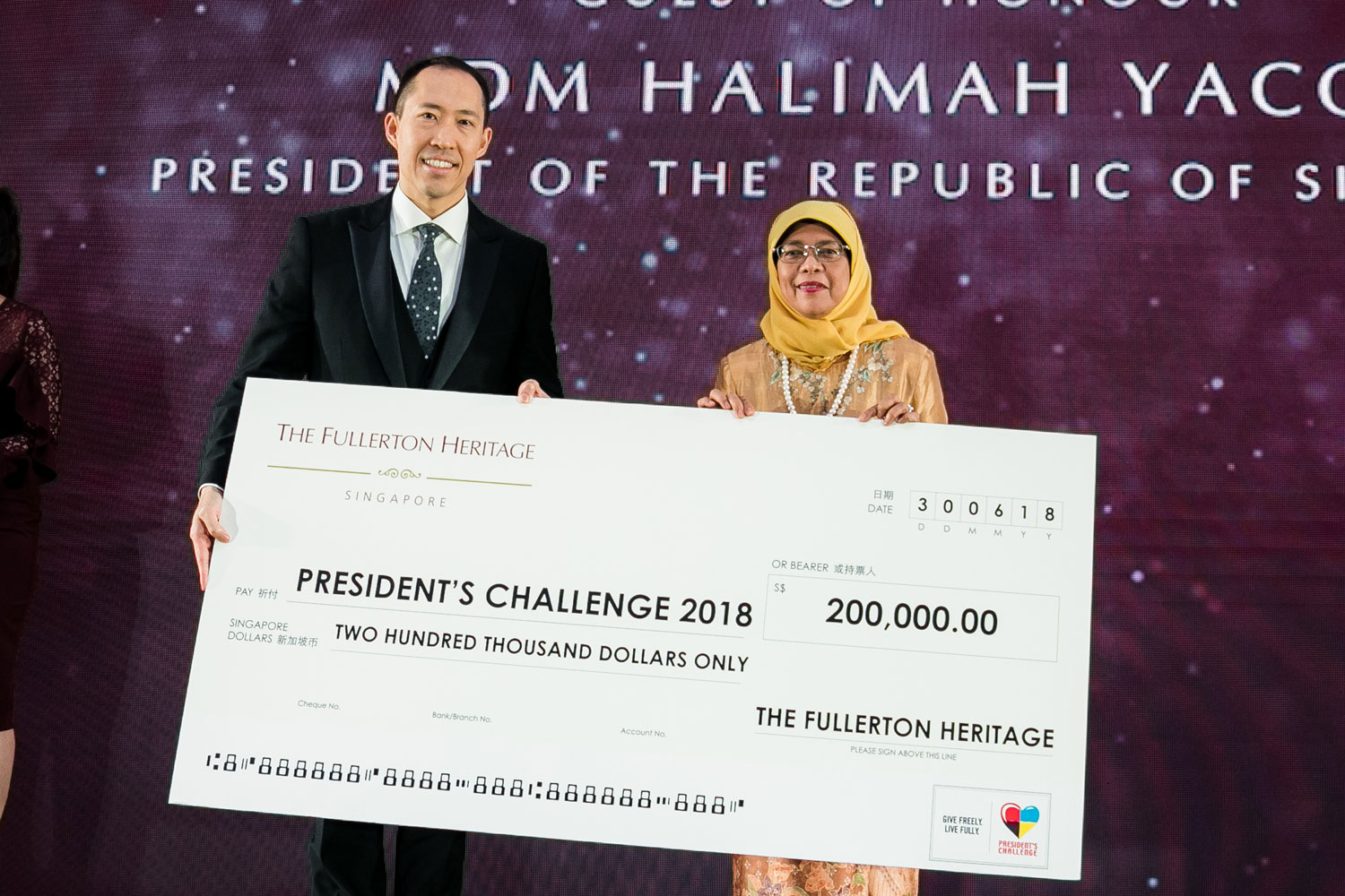 新加坡总统Halimah Yacob从信和集团副主席黄永光手上接过代表善款的支票。