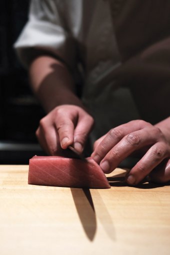 寿司主厨切好后为食客席前奉上优质的寿司。