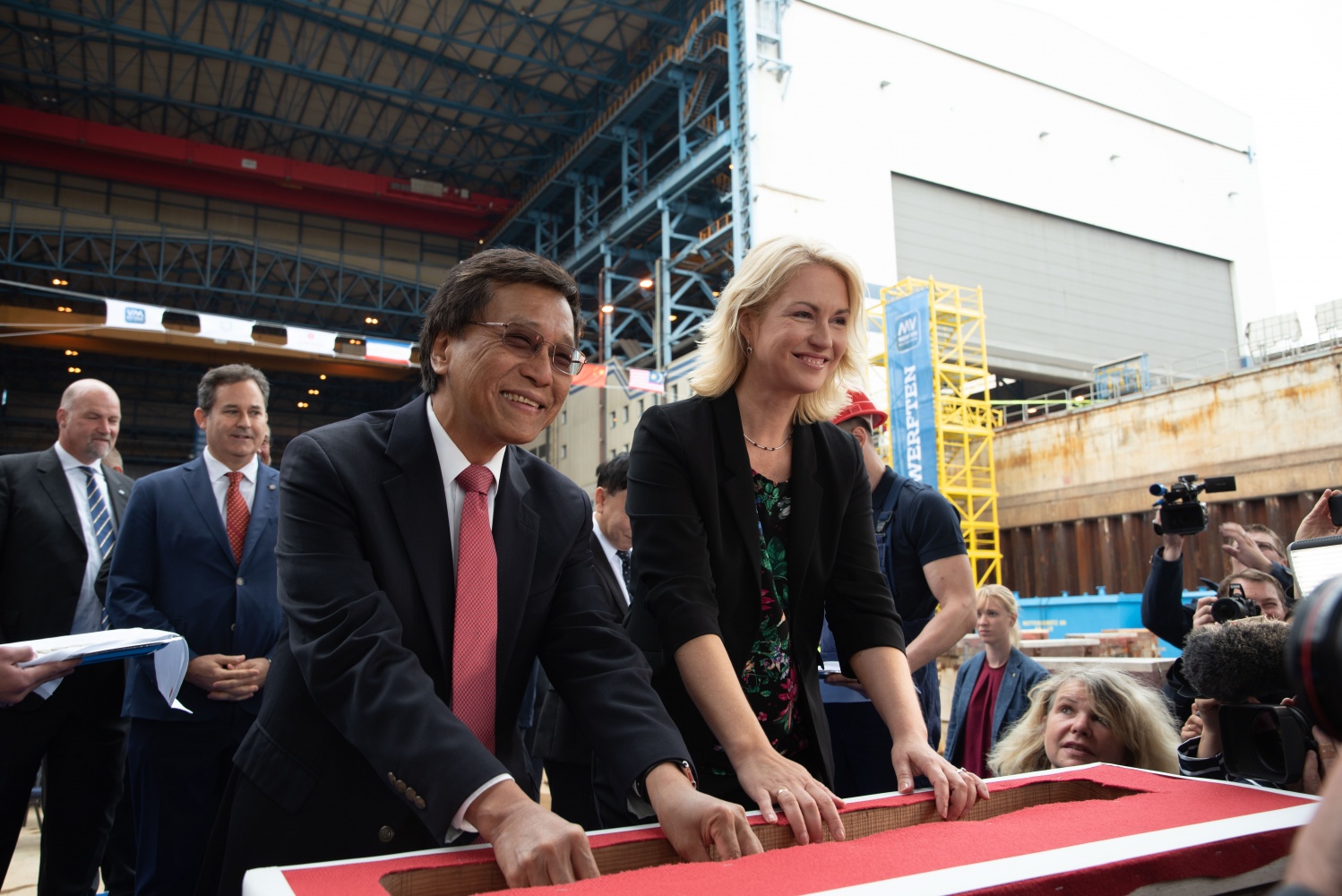 Prime Minister Manuela Schwesig (right) and Genting Hong Kong's Executive Chairman Tan Sri Lim Kok Thay (left) places lucky coins in the keel of Dream Cruises’ new Global Class ship.