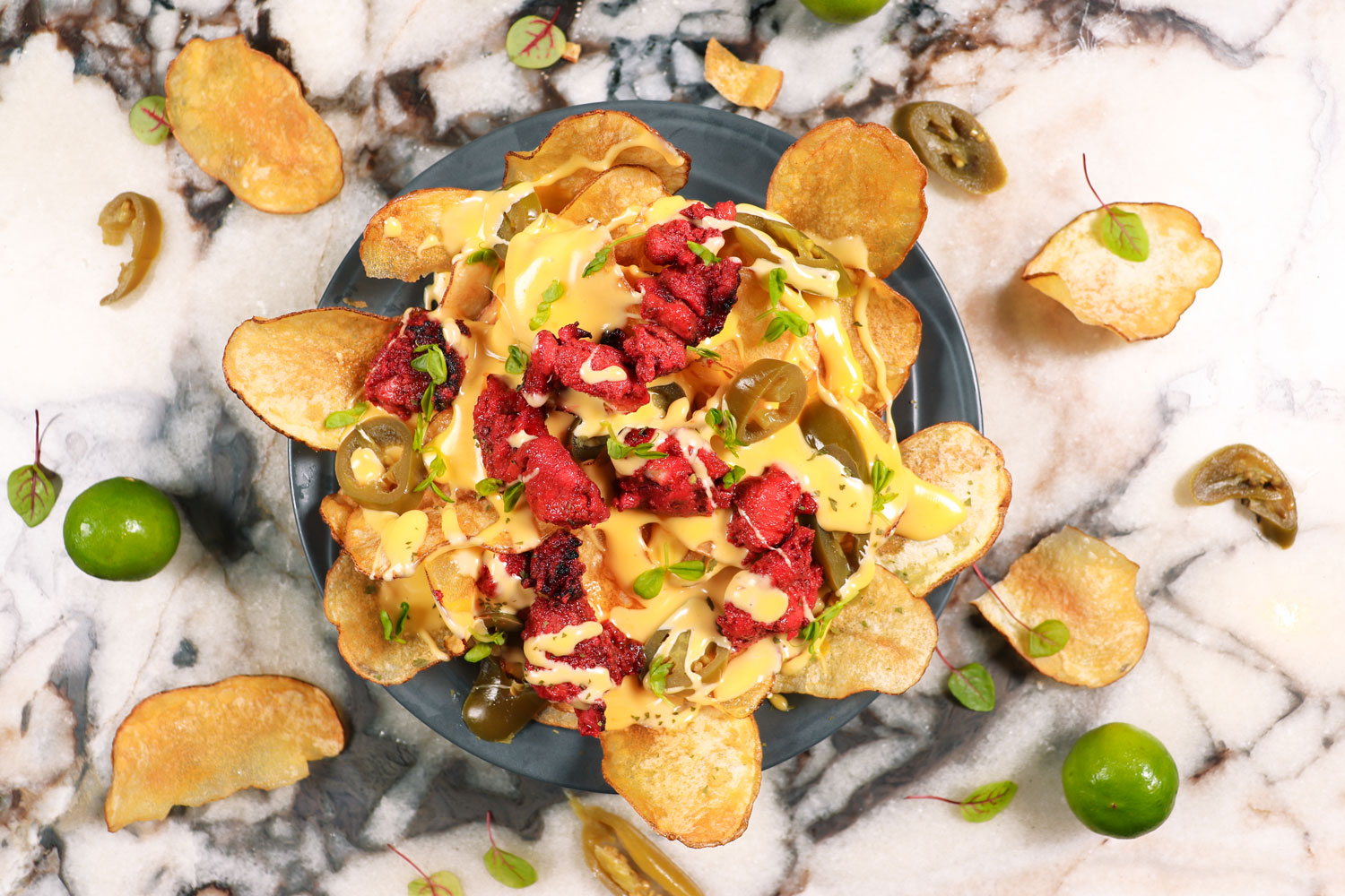 Hand-Cut Crispy Chip Nachos topped with Tandoori Chicken, Jalapeños and Melted Cheddar